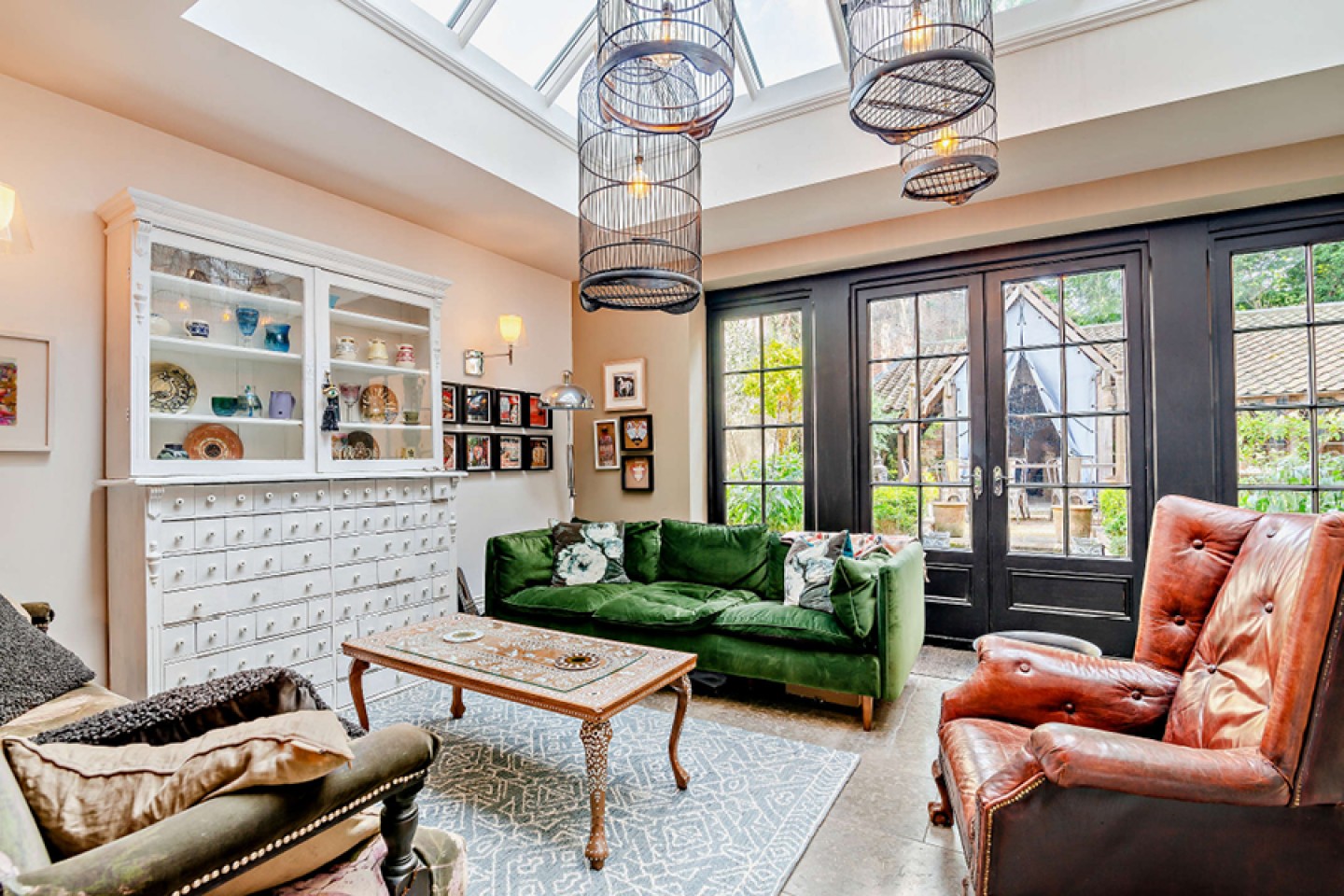 Seating area with eclectic furniture, hanging lighting bird cages and a ceiling lantern